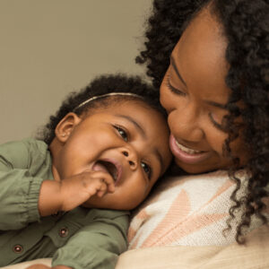 A mother smiling at a toddler in her arms